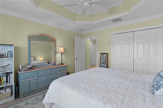 bedroom with a raised ceiling, crown molding, a closet, and ceiling fan