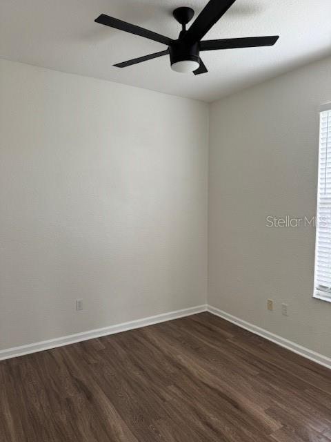 spare room with ceiling fan and dark hardwood / wood-style flooring