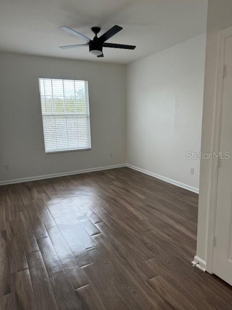 unfurnished room with ceiling fan and dark hardwood / wood-style flooring