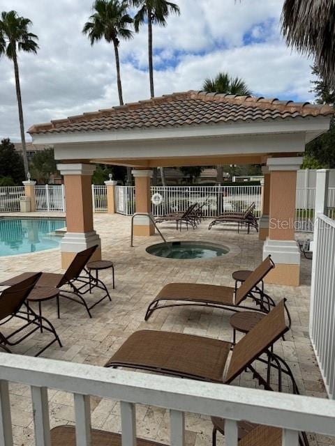 view of patio featuring a gazebo and a swimming pool with hot tub