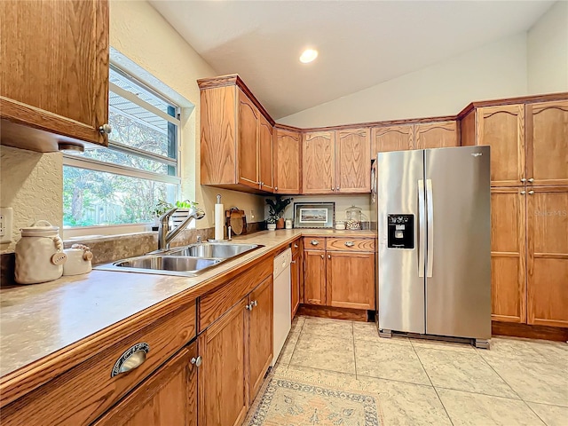 kitchen with dishwasher, sink, stainless steel refrigerator with ice dispenser, lofted ceiling, and light tile patterned floors