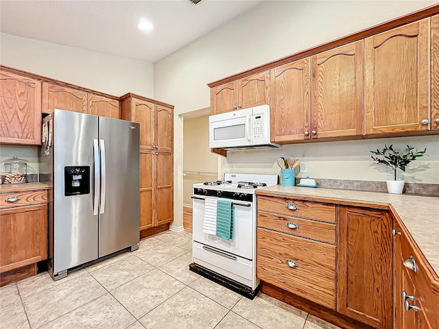 kitchen with light tile patterned floors and white appliances