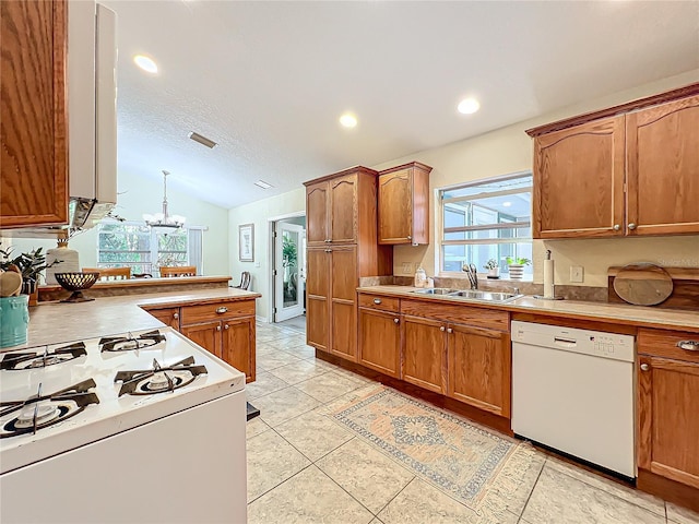 kitchen with sink, a healthy amount of sunlight, white appliances, and a notable chandelier