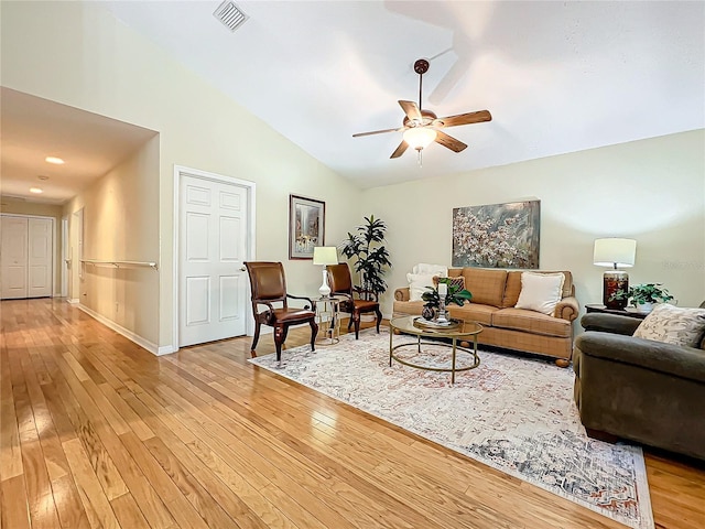 living room featuring ceiling fan, light hardwood / wood-style flooring, and vaulted ceiling