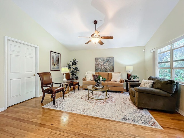 living room with light hardwood / wood-style floors, ceiling fan, and lofted ceiling