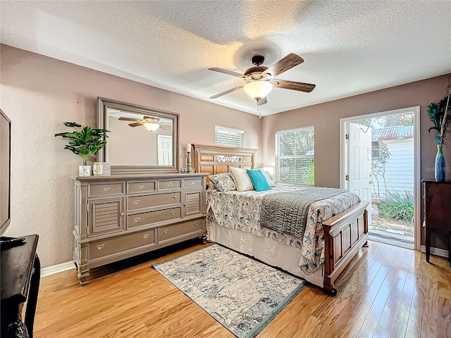 bedroom featuring access to exterior, a textured ceiling, light hardwood / wood-style floors, and ceiling fan