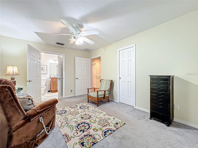 sitting room featuring ceiling fan, a textured ceiling, and light carpet