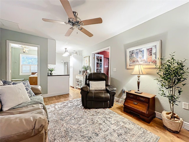 living room with ceiling fan and light wood-type flooring