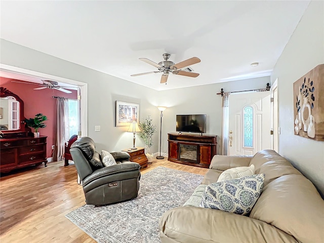 living room with ceiling fan and light hardwood / wood-style flooring