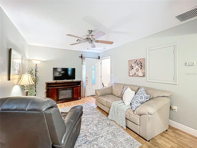 living room with ceiling fan and light wood-type flooring