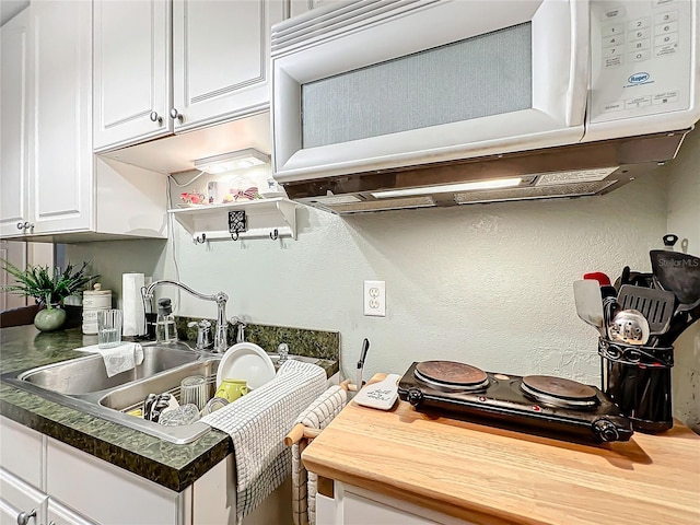 kitchen featuring white cabinetry and sink