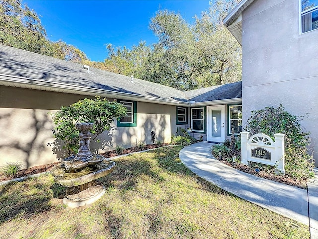 doorway to property with a yard