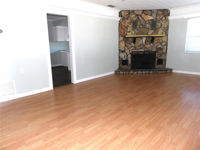 unfurnished living room with a stone fireplace, wood ceiling, and hardwood / wood-style flooring