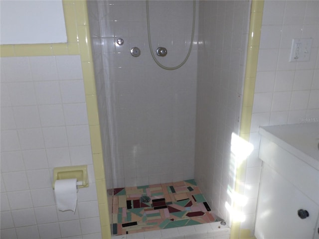 bathroom with a tile shower and tile walls