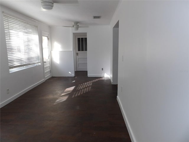 empty room with ceiling fan, dark hardwood / wood-style floors, and ornamental molding