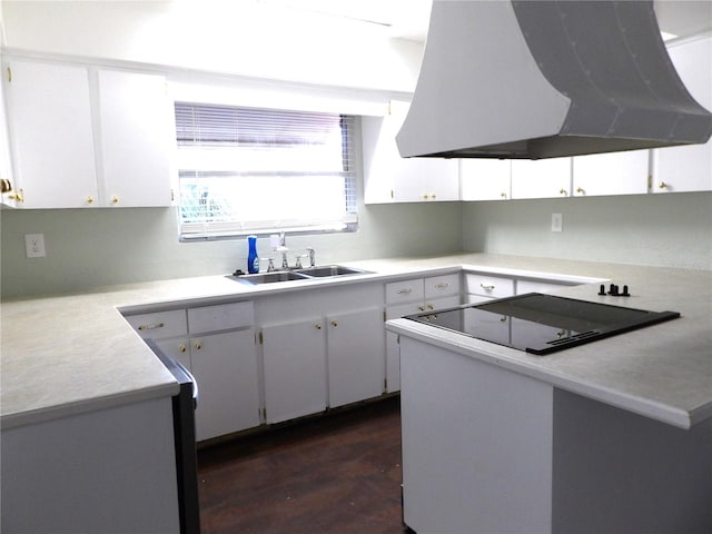 kitchen with sink, dark wood-type flooring, range hood, kitchen peninsula, and white cabinets