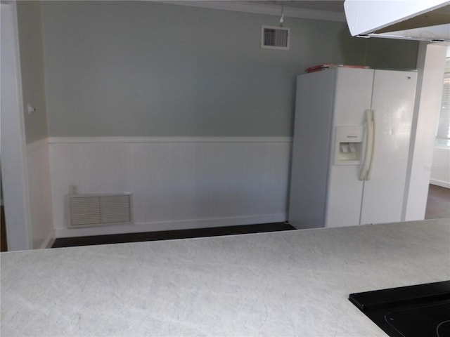 kitchen with white refrigerator with ice dispenser and ornamental molding