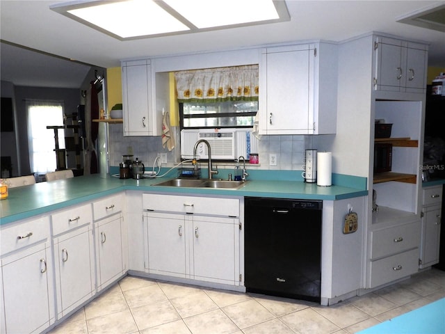 kitchen with tasteful backsplash, sink, white cabinets, black dishwasher, and light tile patterned flooring