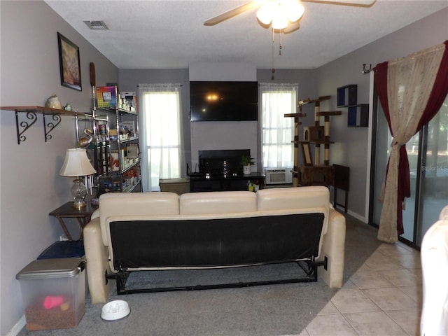 living room with ceiling fan, cooling unit, and light tile patterned floors