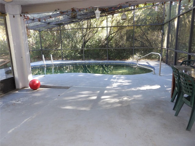 view of pool featuring glass enclosure and a patio