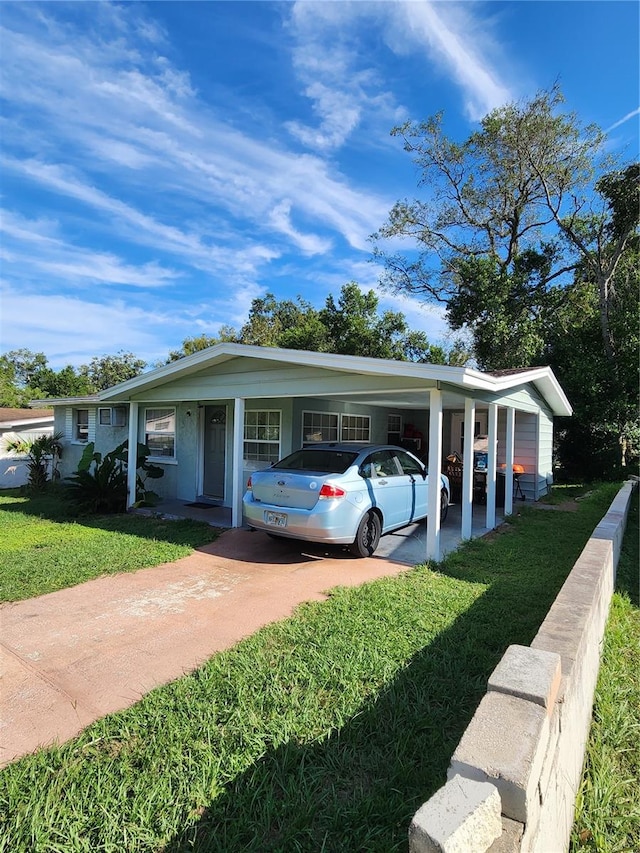 view of front of house with a carport and a front lawn