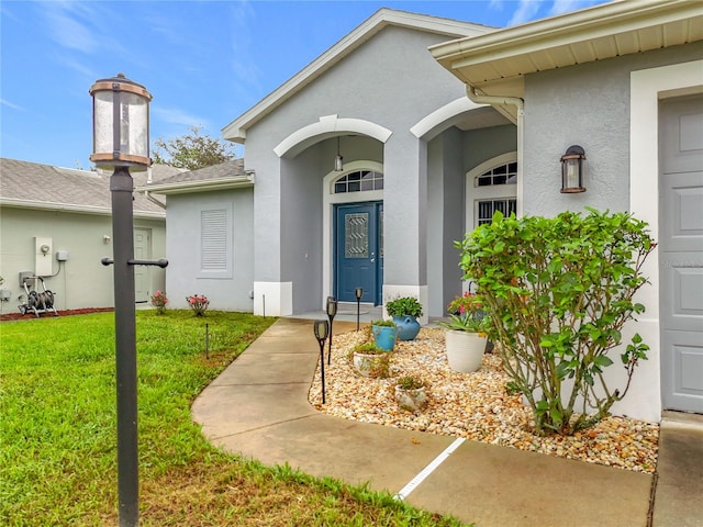 view of exterior entry featuring a yard