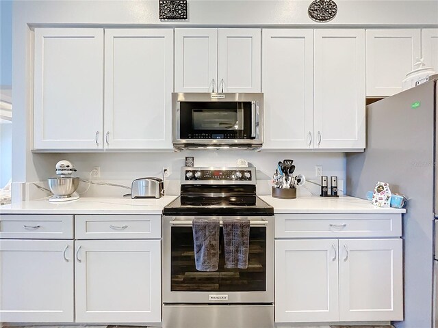 kitchen with white cabinetry and appliances with stainless steel finishes