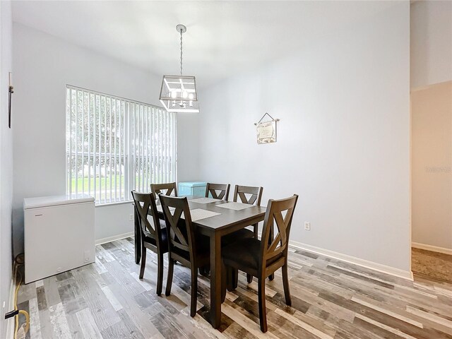 dining room with hardwood / wood-style floors and an inviting chandelier