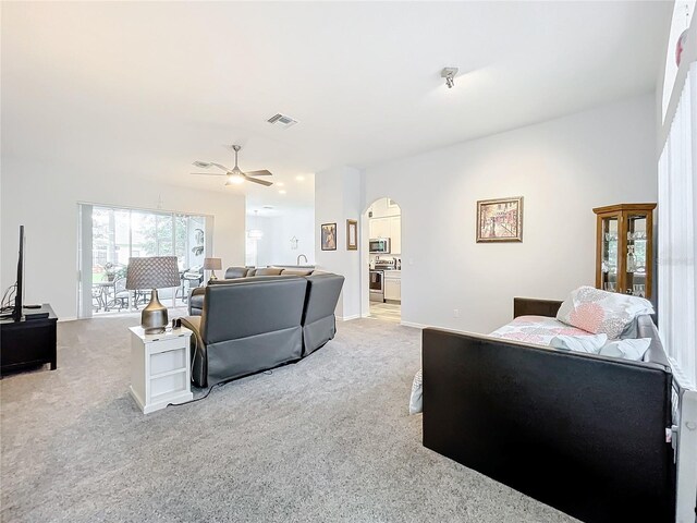 living room with light carpet and ceiling fan