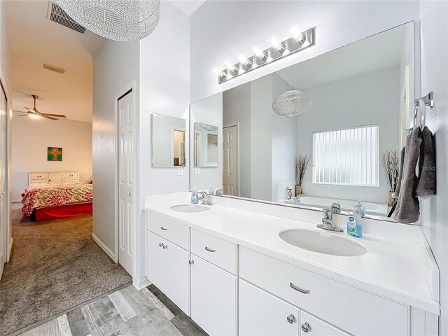 bathroom featuring ceiling fan, vanity, and wood-type flooring