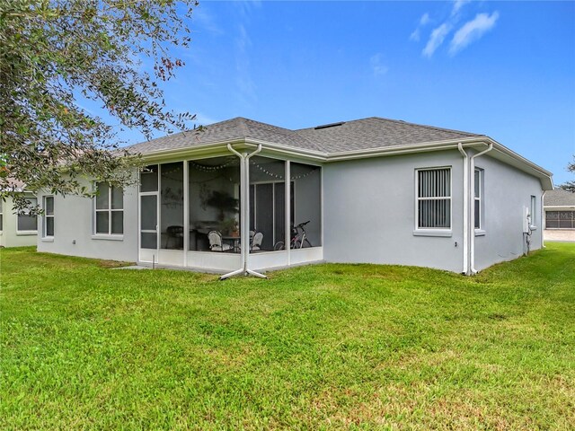 back of property featuring a sunroom and a yard