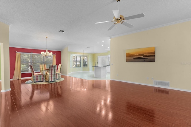 interior space featuring hardwood / wood-style floors, ceiling fan with notable chandelier, a textured ceiling, and ornamental molding