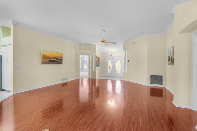 unfurnished living room featuring a textured ceiling, ceiling fan, light hardwood / wood-style floors, and crown molding