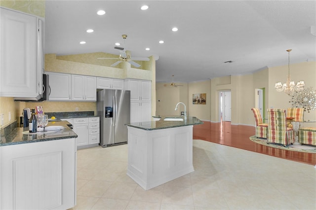 kitchen with a center island with sink, white cabinets, hanging light fixtures, vaulted ceiling, and appliances with stainless steel finishes