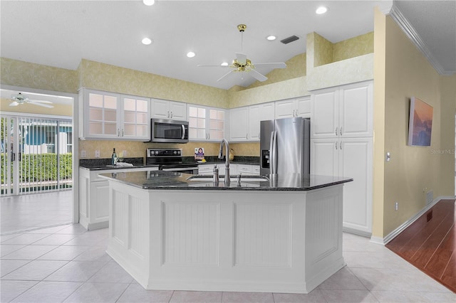 kitchen with sink, stainless steel appliances, a center island with sink, white cabinets, and ornamental molding