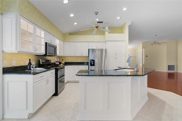 kitchen featuring white cabinets, appliances with stainless steel finishes, lofted ceiling, and an island with sink