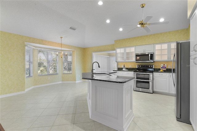 kitchen featuring white cabinetry, sink, pendant lighting, a textured ceiling, and appliances with stainless steel finishes