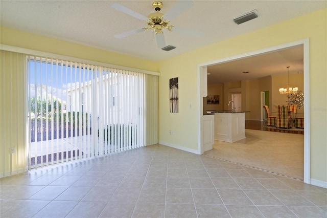 spare room featuring light tile patterned floors, ceiling fan with notable chandelier, a textured ceiling, and sink