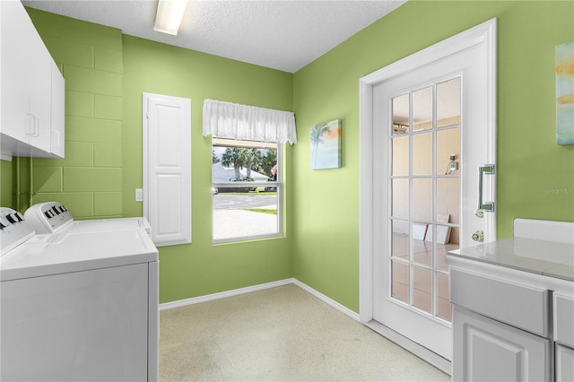 laundry area with cabinets, independent washer and dryer, and a textured ceiling