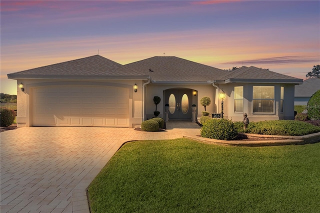 view of front of property featuring a garage and a yard