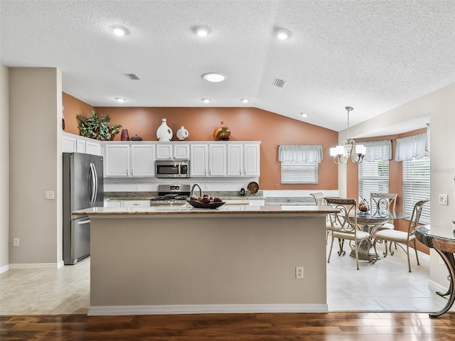 kitchen featuring decorative light fixtures, a notable chandelier, light hardwood / wood-style flooring, appliances with stainless steel finishes, and white cabinets