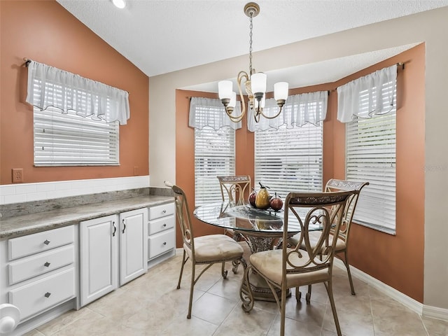 dining room featuring light tile patterned floors, lofted ceiling, and a chandelier