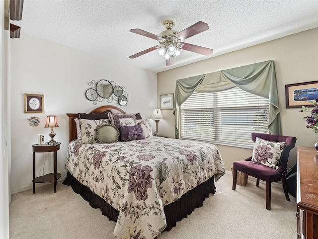 carpeted bedroom featuring a textured ceiling and ceiling fan