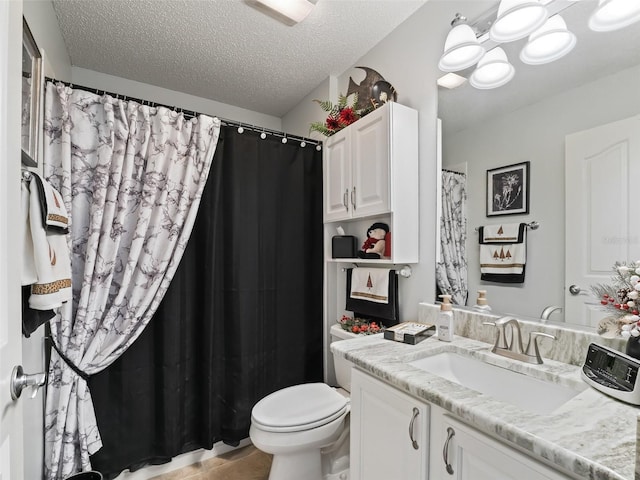 bathroom featuring tile patterned floors, a textured ceiling, toilet, and vanity