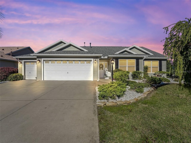 single story home with a garage and a lawn