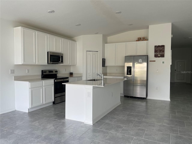 kitchen featuring sink, vaulted ceiling, a center island with sink, appliances with stainless steel finishes, and white cabinets