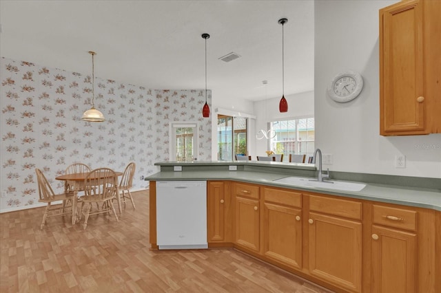 kitchen featuring white dishwasher, sink, light hardwood / wood-style flooring, decorative light fixtures, and kitchen peninsula