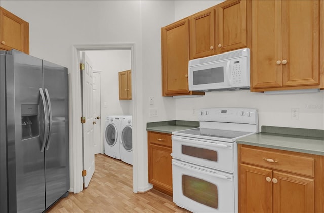 kitchen featuring washer and clothes dryer, white appliances, and light hardwood / wood-style flooring