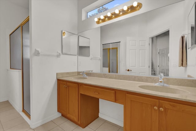 bathroom featuring tile patterned flooring, vanity, and a shower with door