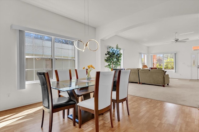 dining space with light hardwood / wood-style flooring and ceiling fan with notable chandelier